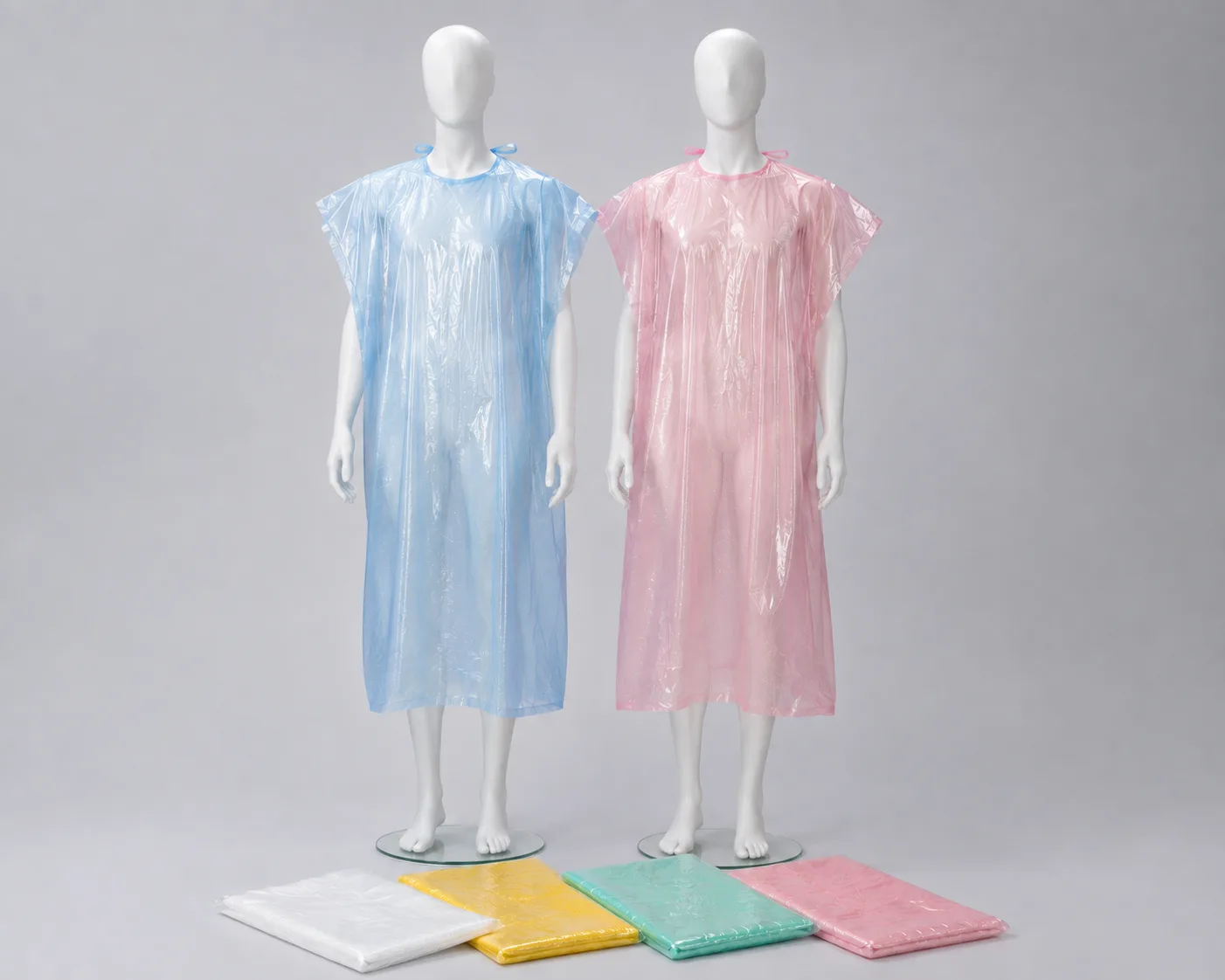Blue and pink polyethylene salon capes on mannequins with additional colour options